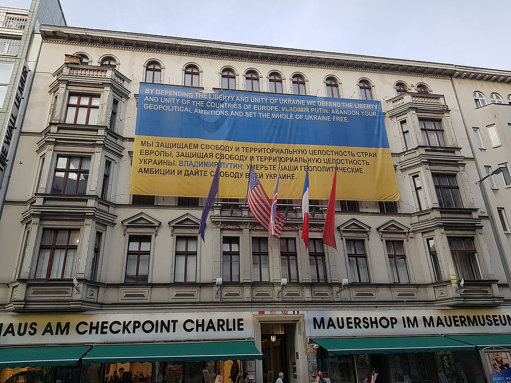 Brunk and Hakimi]: “Plaque supporting territorial integrity of Ukraine at Checkpoint Charlie”. This file is licensed under the Creative Commons Attribution-Share Alike 4.0 International licence.